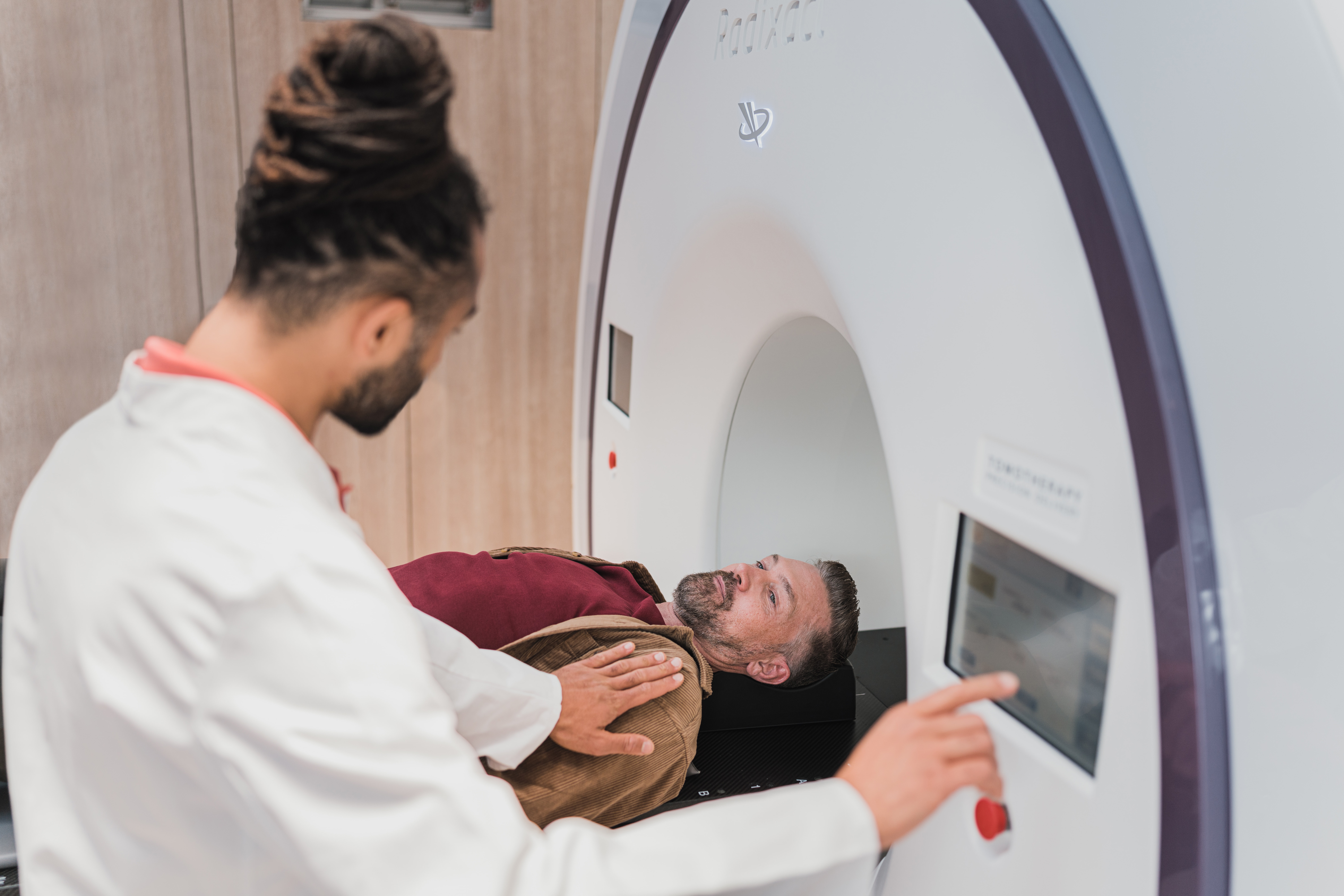 Radiology technician introducing a person in a scanner.