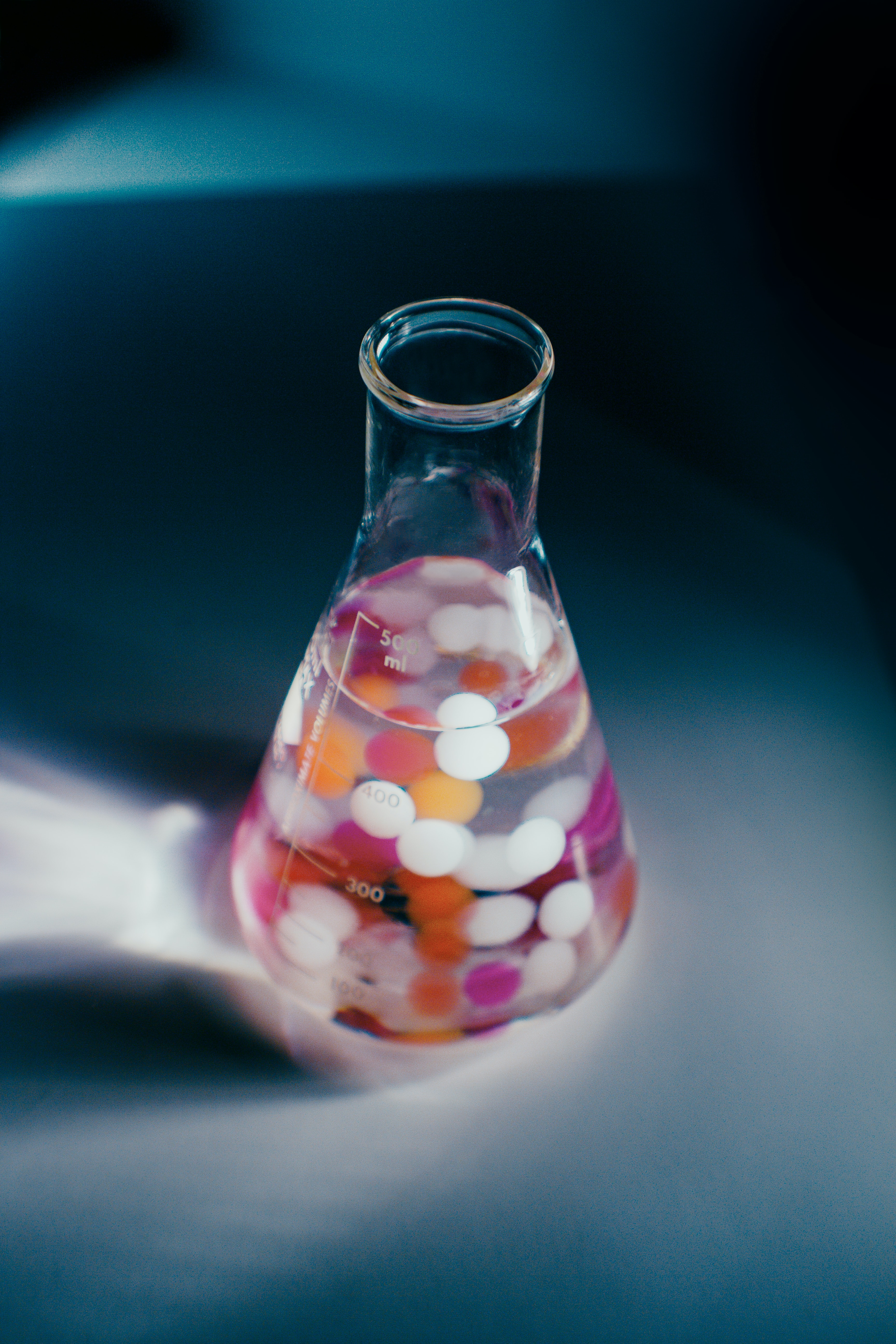 Science flask with coloured spheres submerged in liquid.