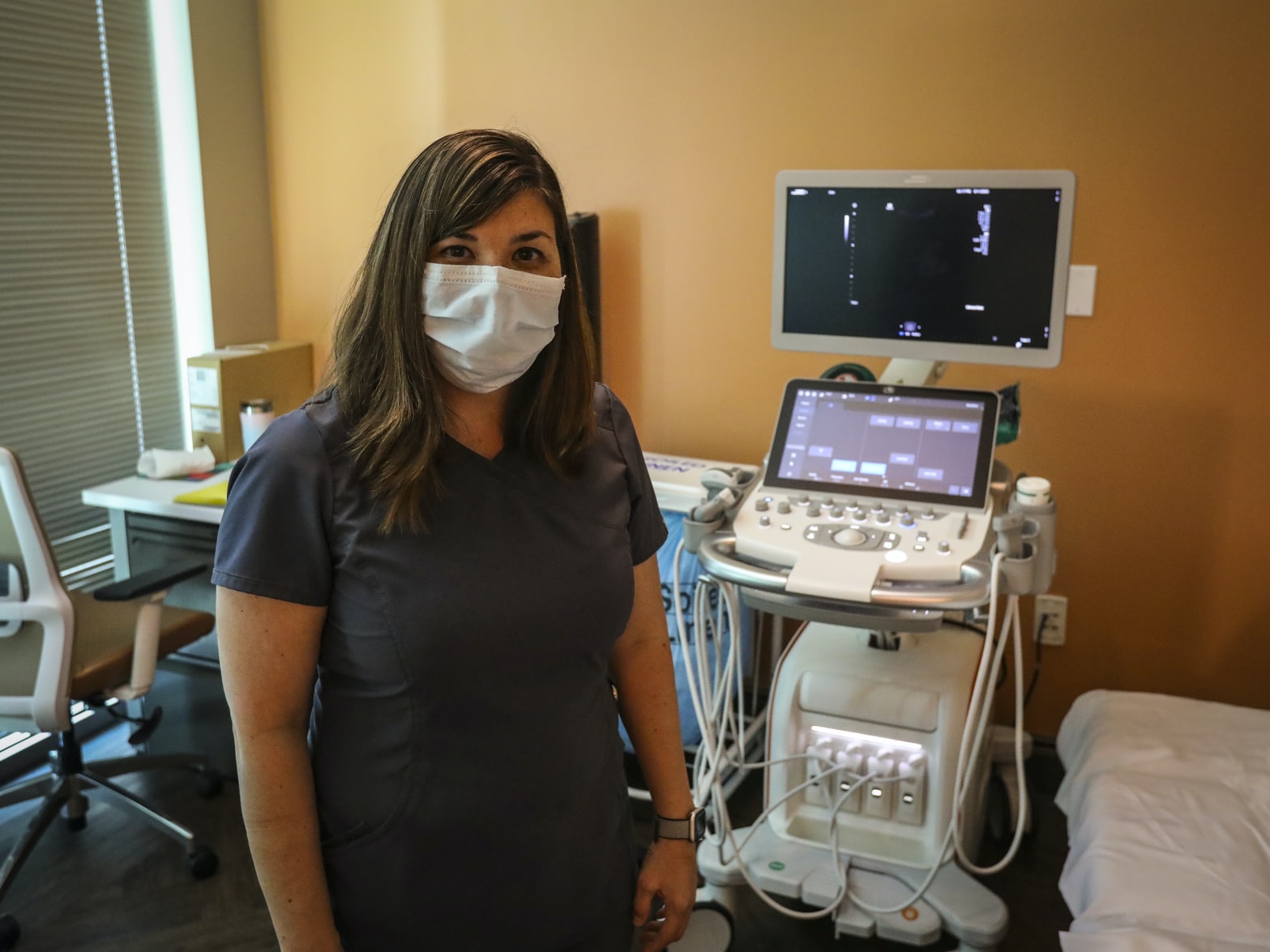 Ultrasound operator standing in front of machine