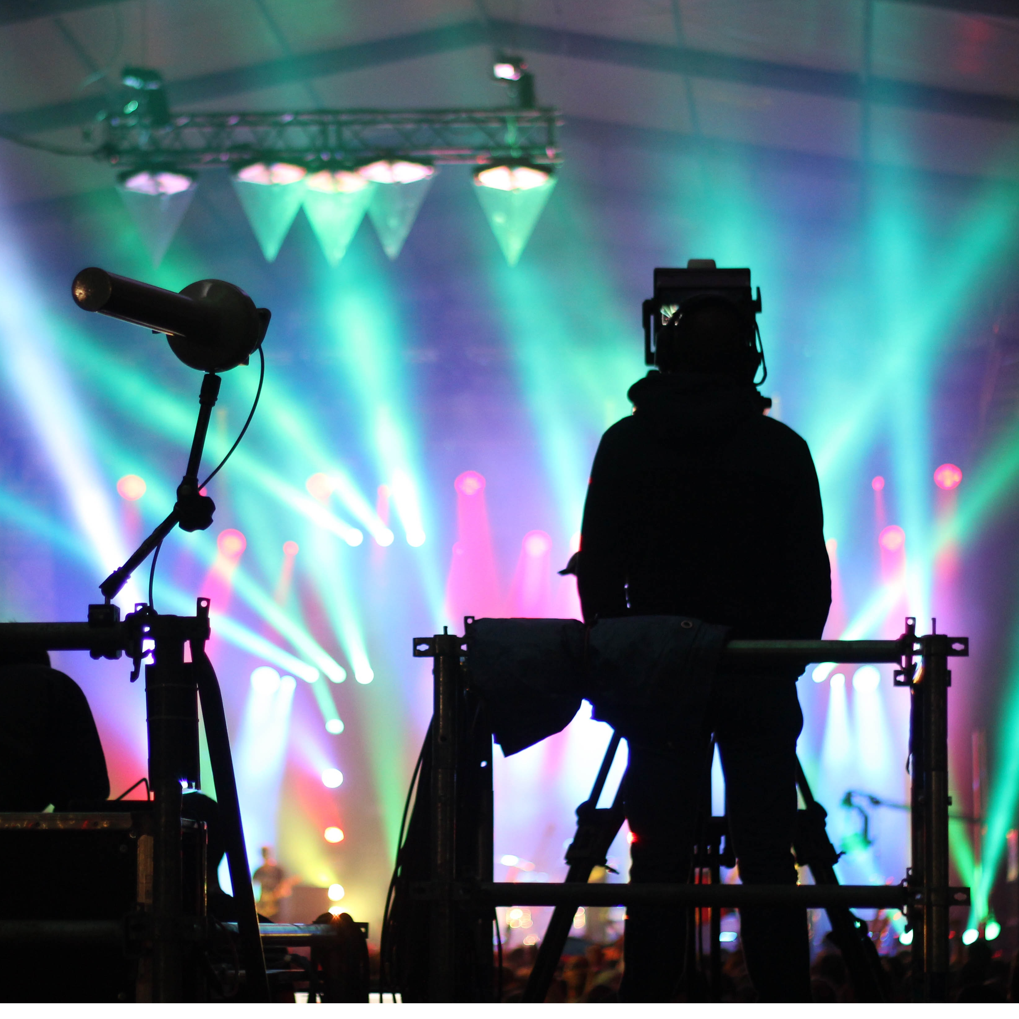 Silhouette of a man standing on a music venue with many stage lights